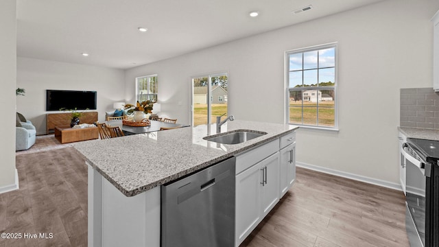 kitchen with visible vents, electric range oven, a sink, light wood-style floors, and stainless steel dishwasher