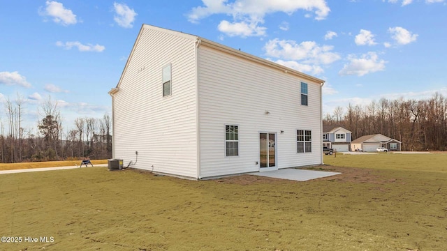 rear view of house featuring a yard, a patio, and central AC