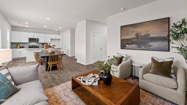 living room with recessed lighting, baseboards, and wood finished floors