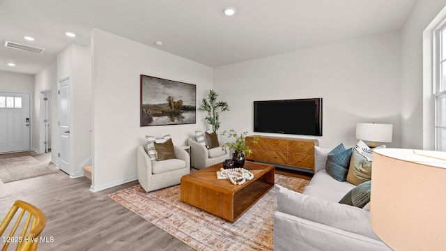 living room featuring visible vents, recessed lighting, baseboards, and wood finished floors