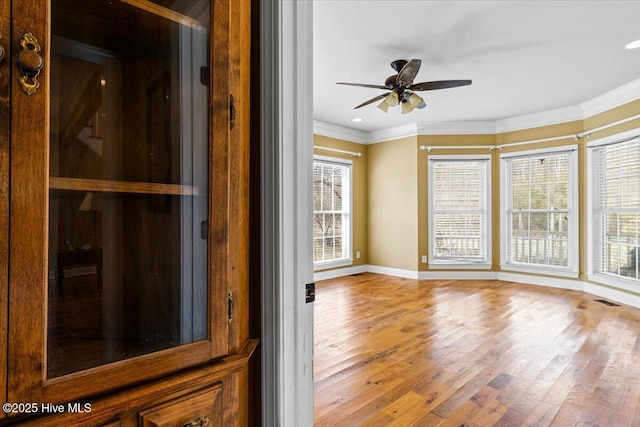 unfurnished sunroom featuring visible vents and ceiling fan