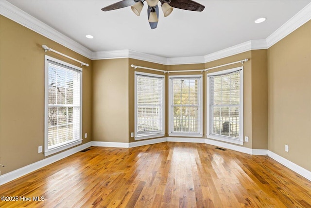 spare room with baseboards, wood-type flooring, ceiling fan, and crown molding