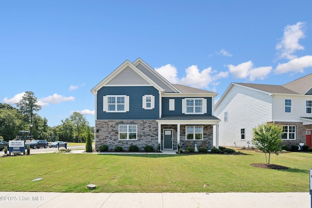 craftsman house with a front yard and stone siding