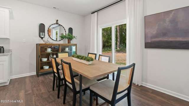 dining space with dark wood-type flooring, visible vents, and baseboards