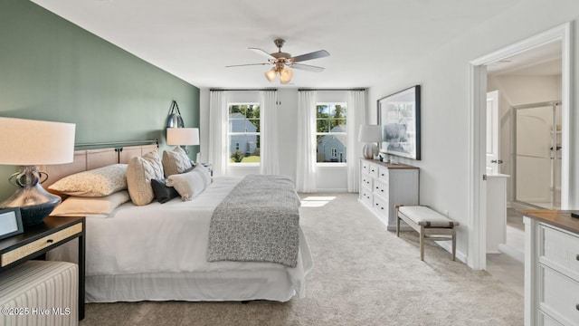 bedroom with ceiling fan, ensuite bath, and carpet