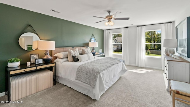 carpeted bedroom featuring visible vents, a ceiling fan, and baseboards