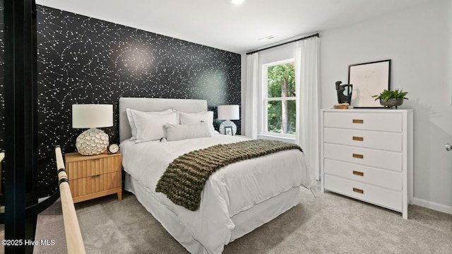 bedroom with visible vents, carpet, wallpapered walls, baseboards, and an accent wall