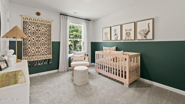 carpeted bedroom with visible vents, baseboards, and a nursery area