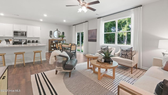 living area featuring recessed lighting, baseboards, wood finished floors, and a ceiling fan