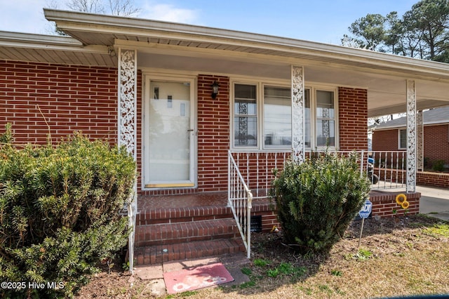 entrance to property with brick siding and covered porch