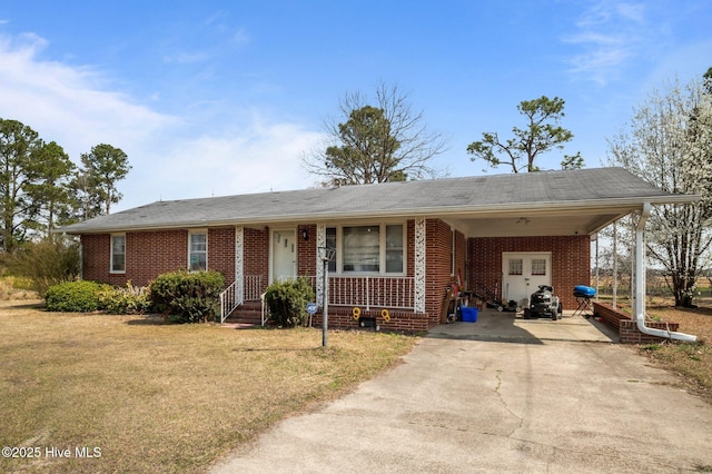 single story home featuring a carport, a front yard, brick siding, and driveway