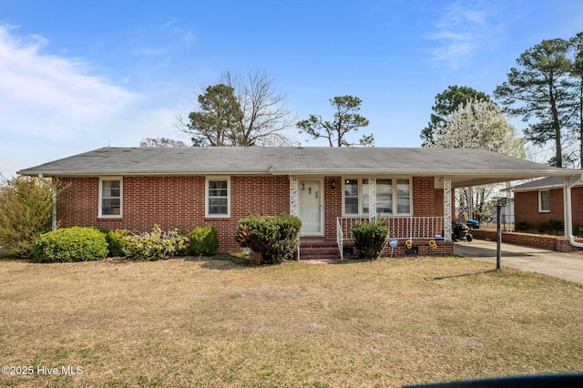 ranch-style house with an attached carport, concrete driveway, brick siding, and a front yard