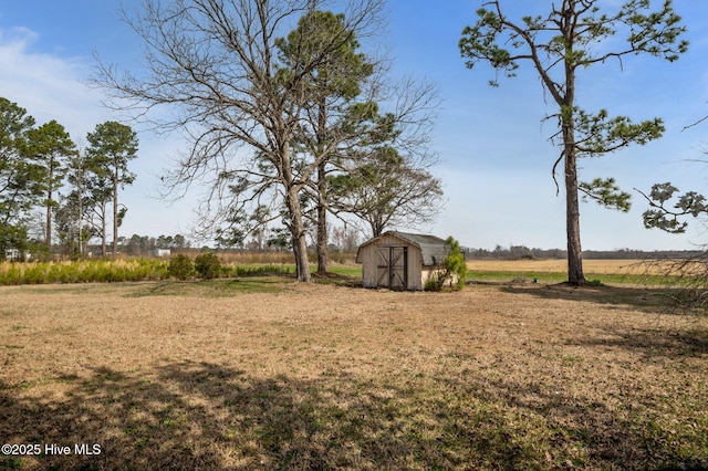 view of yard with a storage unit, an outbuilding, and a rural view