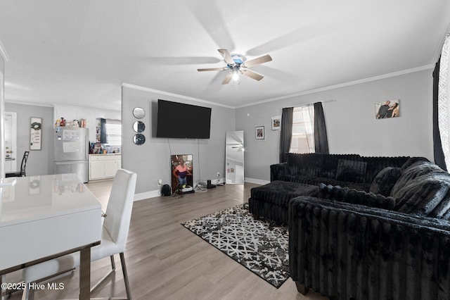 living area with a wealth of natural light, ceiling fan, and ornamental molding