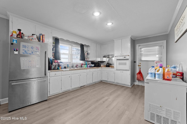 kitchen with open shelves, freestanding refrigerator, oven, light countertops, and white cabinetry