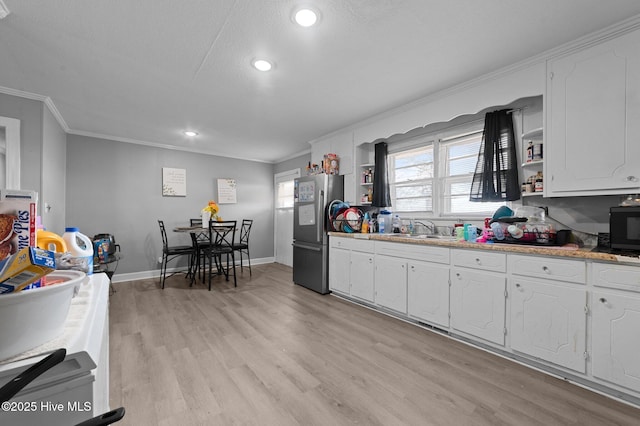 kitchen with ornamental molding, white cabinetry, freestanding refrigerator, and open shelves