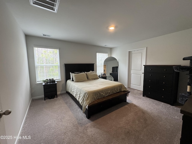 carpeted bedroom with visible vents, multiple windows, and baseboards