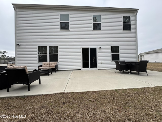 back of property with an outdoor living space and a patio