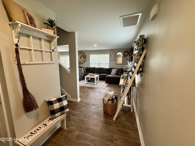 corridor with dark wood-type flooring and baseboards