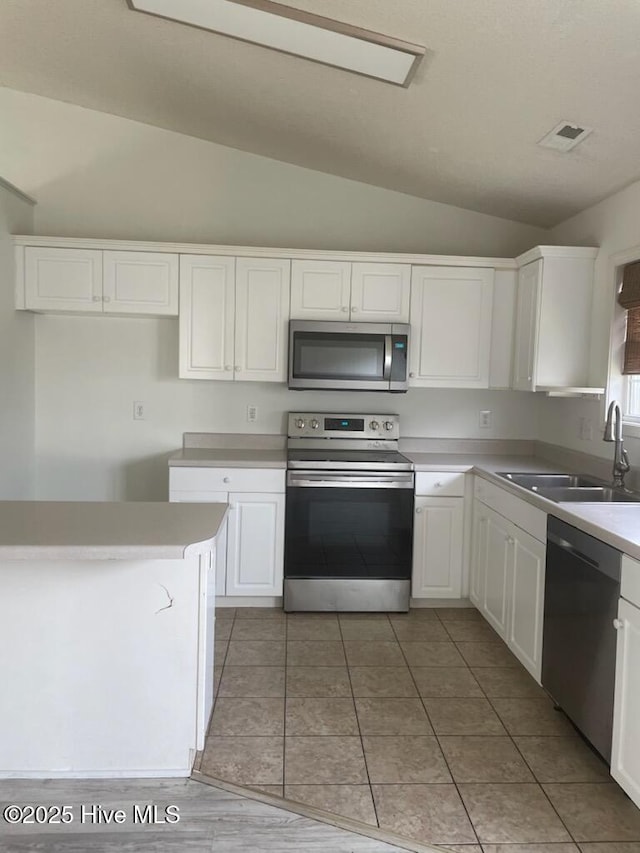 7223 Konlack Ct, Wilmington, NC 28411 - kitchen with appliances with stainless steel finishes, a sink, white cabinetry, and lofted ceiling