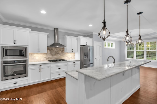 1115 Eldora Ct, Leland, NC 28451 - kitchen with stainless steel appliances, wall chimney range hood, white cabinets, backsplash, and ornamental molding