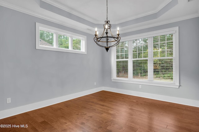 1115 Eldora Ct, Leland, NC 28451 - empty room with a chandelier, a tray ceiling, hardwood / wood-style floors, crown molding, and baseboards