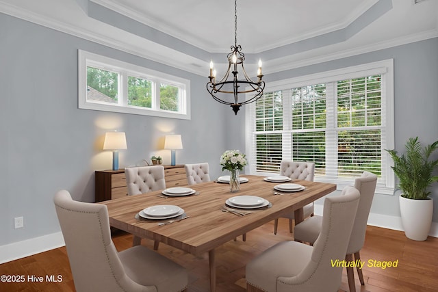 1115 Eldora Ct, Leland, NC 28451 - dining area with a chandelier, a tray ceiling, ornamental molding, baseboards, and wood finished floors