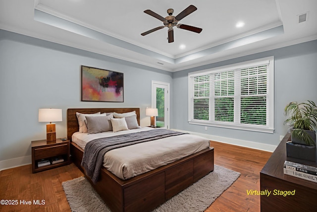 1115 Eldora Ct, Leland, NC 28451 - bedroom with a tray ceiling, crown molding, baseboards, wood finished floors, and a ceiling fan