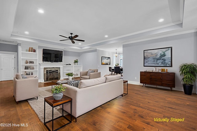 1115 Eldora Ct, Leland, NC 28451 - living room featuring a tray ceiling, hardwood / wood-style flooring, ceiling fan, ornamental molding, and a fireplace