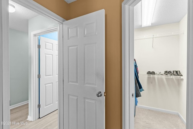 hall featuring baseboards and a textured ceiling