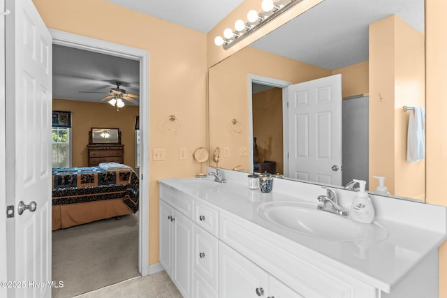 ensuite bathroom with a sink, double vanity, ceiling fan, and ensuite bathroom