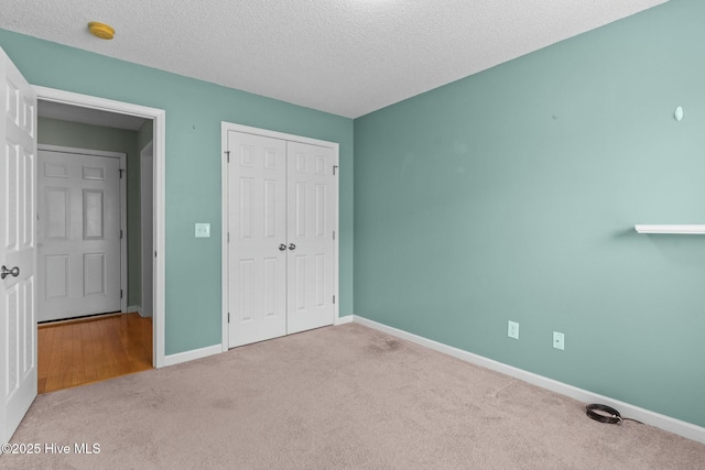 unfurnished bedroom with a closet, baseboards, and a textured ceiling