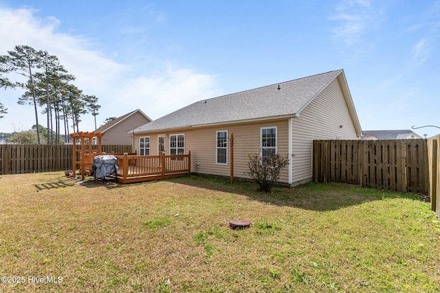 back of house with a lawn, a wooden deck, and a fenced backyard