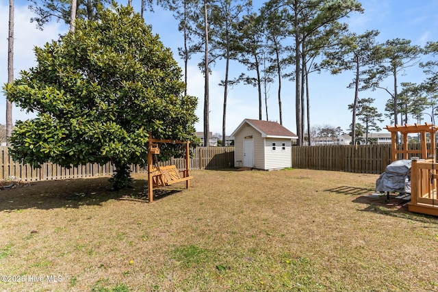 view of yard with a storage unit, a fenced backyard, and an outdoor structure