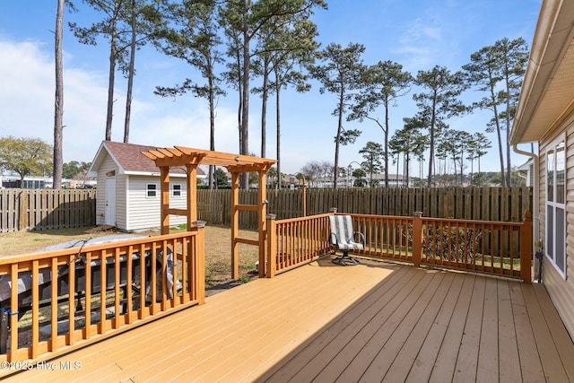 deck with an outdoor structure, a fenced backyard, and a pergola