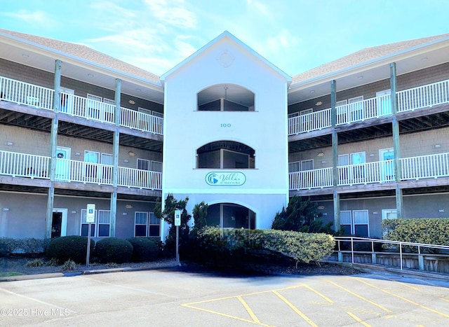 view of building exterior with uncovered parking