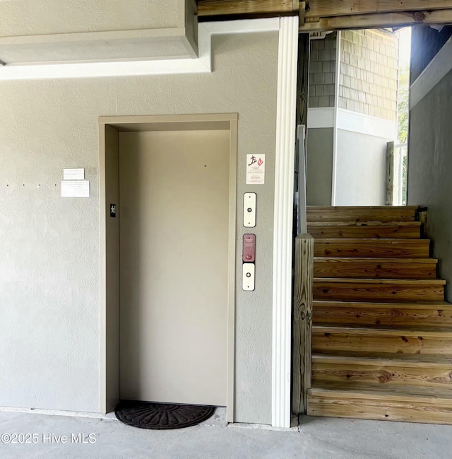 property entrance featuring stucco siding and elevator