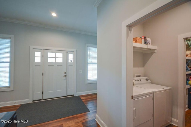 foyer featuring dark wood finished floors, crown molding, washing machine and dryer, and a wealth of natural light