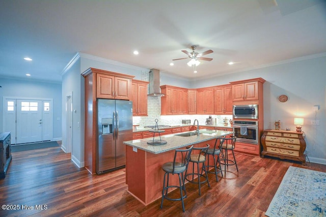 kitchen featuring a sink, dark wood-style floors, appliances with stainless steel finishes, wall chimney exhaust hood, and ceiling fan