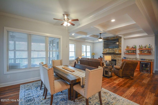 dining room with beamed ceiling, coffered ceiling, dark wood finished floors, and a ceiling fan