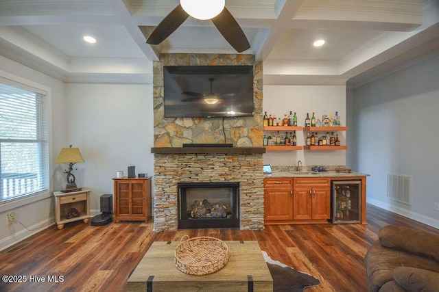 living area with visible vents, beverage cooler, dark wood finished floors, a fireplace, and wet bar