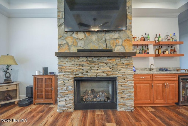 details with wood finished floors, wet bar, beverage cooler, and ornamental molding