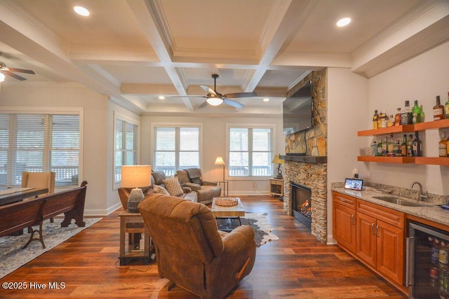 living room with wine cooler, dark wood finished floors, wet bar, and a ceiling fan