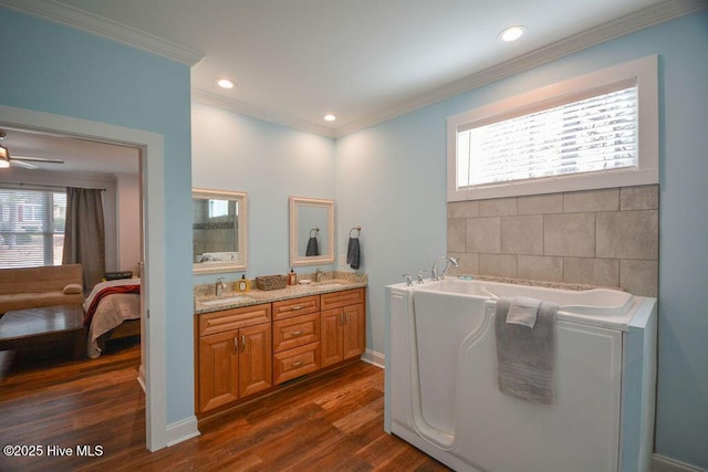 full bath featuring crown molding, wood finished floors, and a sink