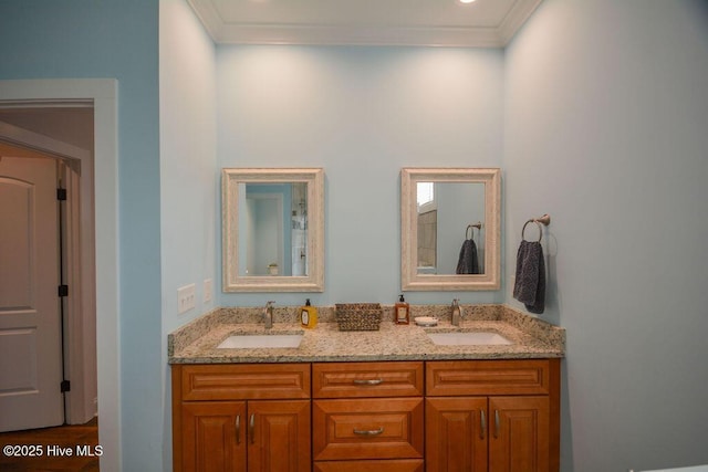 bathroom featuring double vanity, crown molding, and a sink