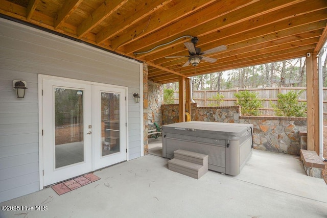 view of patio / terrace with french doors, a hot tub, ceiling fan, and fence