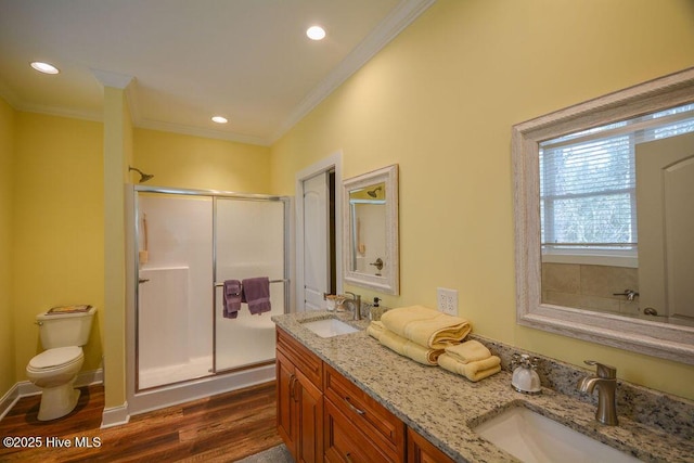 bathroom with a shower stall, wood finished floors, ornamental molding, and a sink