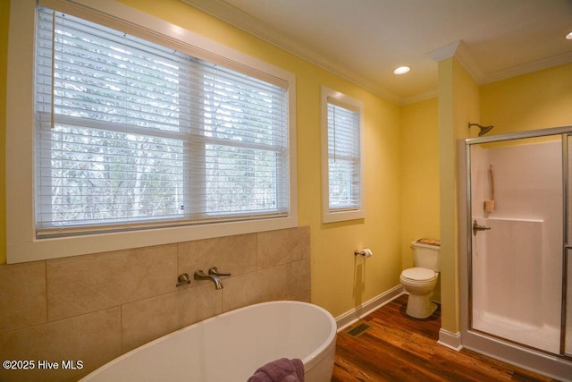 full bathroom with visible vents, crown molding, a freestanding tub, a stall shower, and wood finished floors