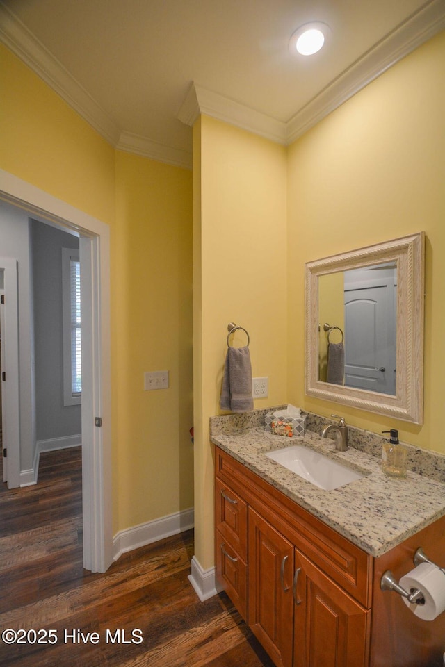 bathroom featuring ornamental molding, vanity, baseboards, and wood finished floors