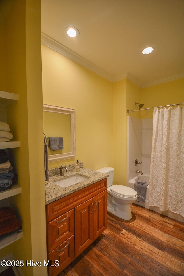 bathroom featuring vanity, shower / bathtub combination with curtain, wood finished floors, ornamental molding, and toilet